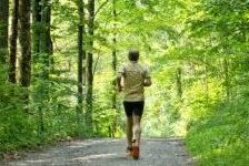 Ein sportlicher Mann läuft in einem grünen Wald.