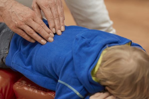 Ein kleiner Junge bekommt eine Rückenbehandlung.