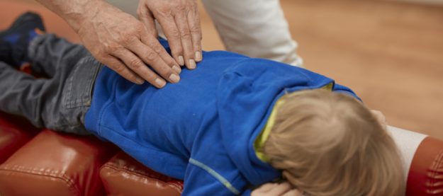 FriedemannTheill_Chiropraktik bei Kindern_Generation Lockdonw Ein kleiner Junge bekommt eine Rückenbehandlung.