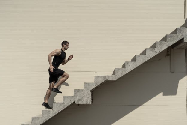 Ein starker athletischer Man läuft die Treppe hoch.
