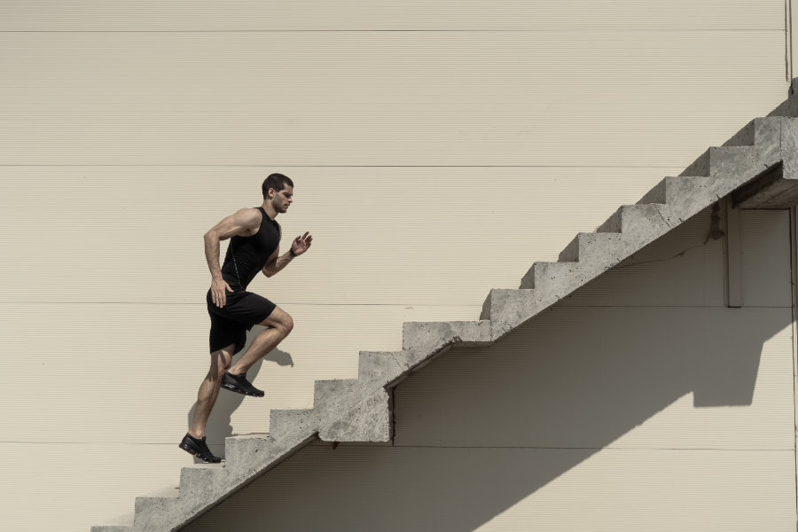 Ein starker athletischer Man läuft die Treppe hoch.