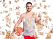 Ein junger Mann hält einen Basketball zwischen Arm und Hüfte. Um ihn herum fliegen viele 50€-Scheine.
