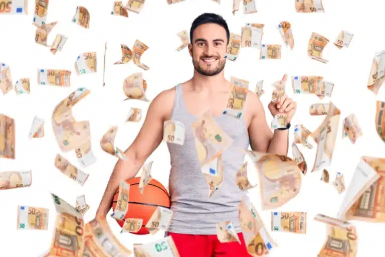 Ein junger Mann hält einen Basketball zwischen Arm und Hüfte. Um ihn herum fliegen viele 50€-Scheine.