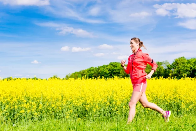 Pollenflug_900x600 Eine junge Frau joggt durch ein Rapsfeld.