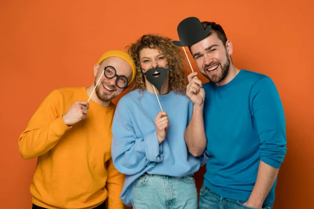 Humor_900x600 Eine Gruppe Freunde spielt mit Pappgegenständen.